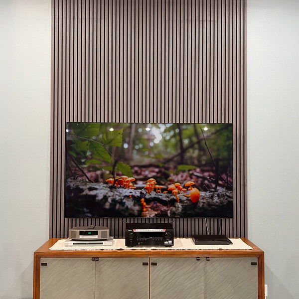 Modern interior with a television displaying nature scene, below a wooden slat panel.
