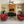 Modern living room with red couches, wooden wall, and ceiling fan.
