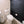 Bathroom with a toilet against a black brick wall.