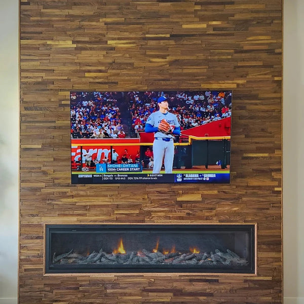 TV mounted on a wooden wall displaying a sports event with a fireplace below.