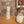Two ceramic vases on a wooden surface with a textured wall in the background
