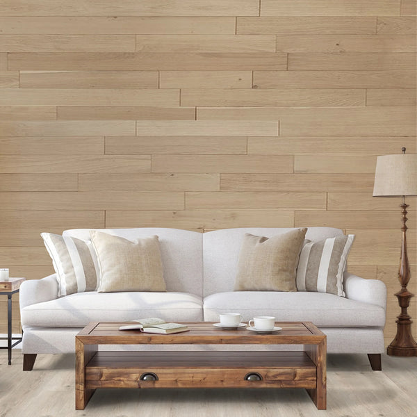 White sofa with beige pillows in a living room setting with wooden coffee table and lamp.