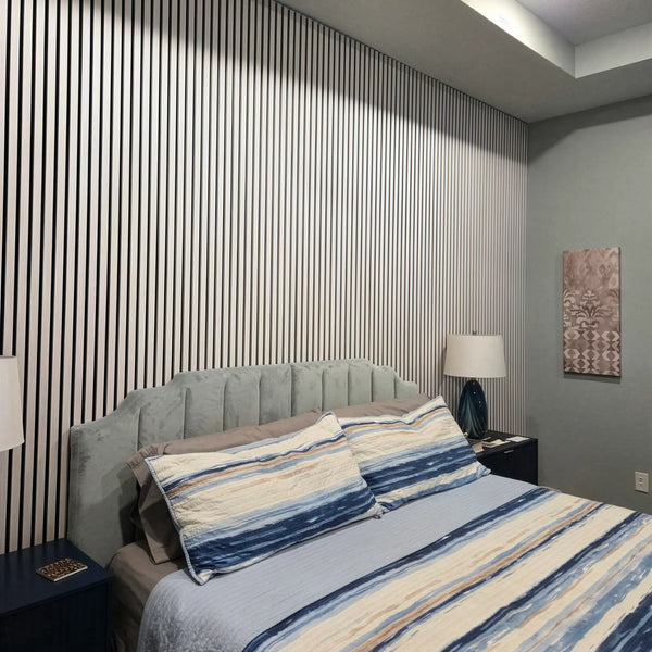 Bedroom with striped wallpaper, bed with blue and beige bedding, and nightstands.
