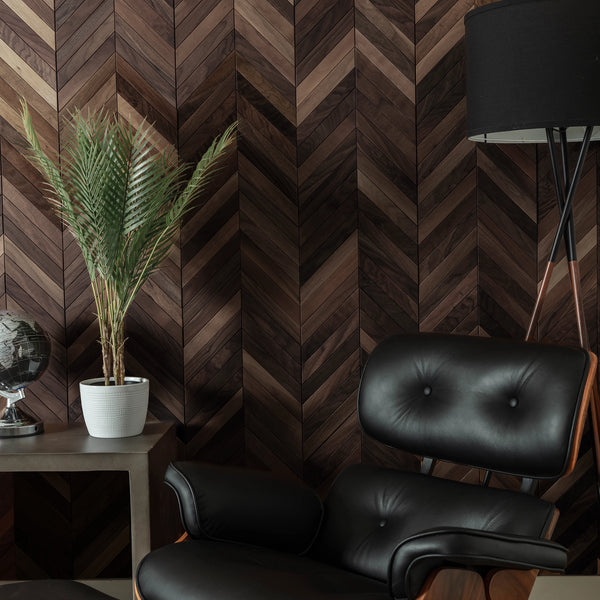 Modern interior with black leather chair, plant, and chevron-patterned wall.