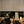 Restaurant interior with black leather booths, wooden chairs, and striped walls.