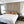 Modern bedroom with a bed, striped headboard, and nightstands with lamps.