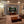 Living room with a large TV displaying a tiger, surrounded by beige walls and furniture.