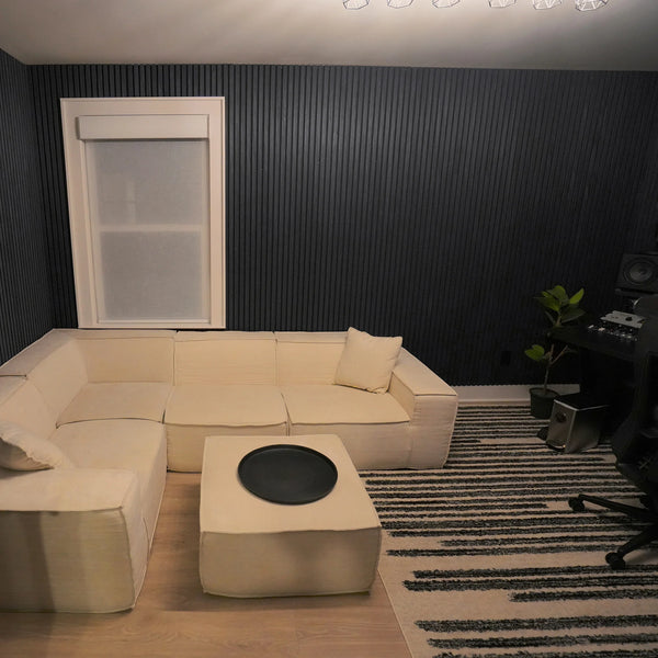 Modern living room with beige sectional sofa, coffee table, and striped rug.