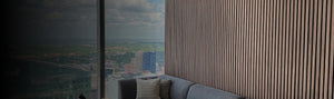Modern interior with a cityscape view from a window, featuring a sofa and striped wall.